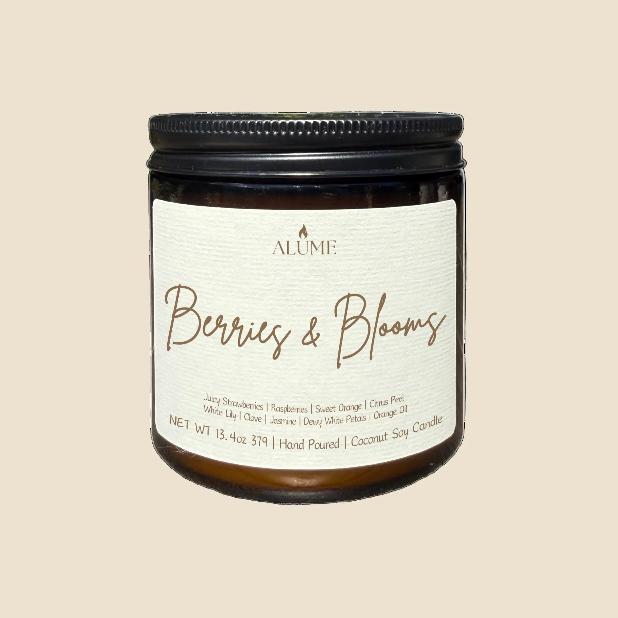 Candle jar labeled 'Berries & Blooms' by Alume on a white background