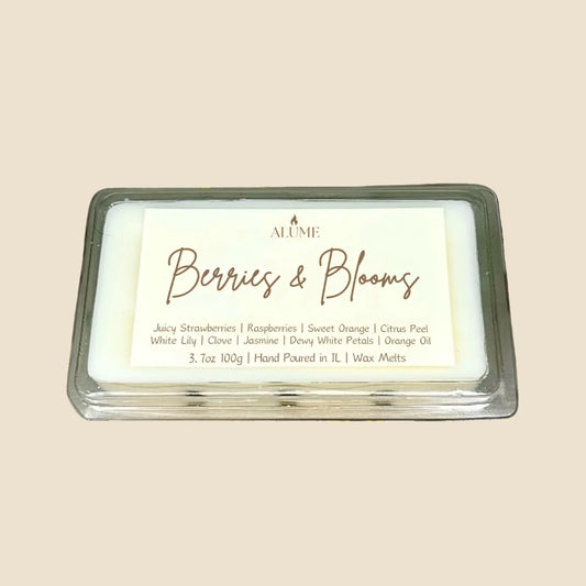 Wax melt with 'Berries & Blooms' fragrance on a stone surface with decorative elements.